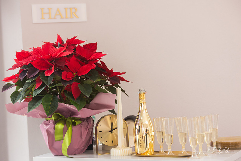 Decor de sarbatori in salonul L Beauty: floare de Craciun, pahare de sampanie si atmosfera calda in zona hair.