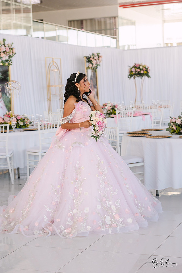 Chelsea Monique Alfaro talking on the phone before leaving for church during her quinceañera day in Belize, captured in a candid and natural moment.